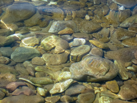 Horizontal photo of smooth stones lying underwater on a sea beach.の写真素材