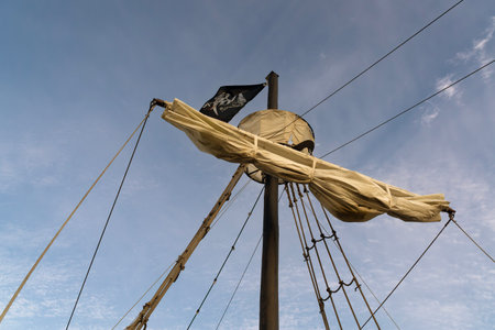 A horizontal photo of the top of a pirate ship's mast against the sky.の写真素材