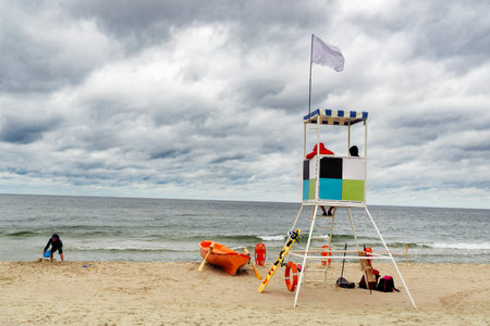 Horizontal photo of an empty sea beach with a lifeguard tower during cloudy weatherの写真素材