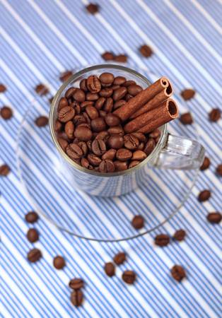 coffee beans in a glass cup with cinnamon, close-up