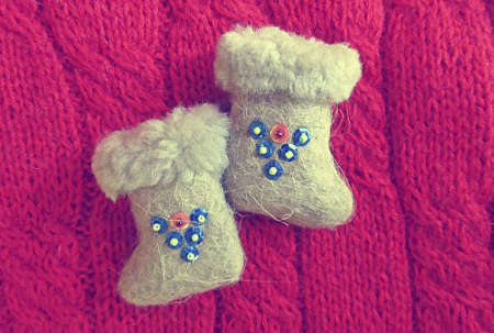 small felt boots with sequins on red sweater closeup