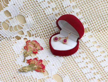 gold earrings with ruby  in gift box, close-upの写真素材
