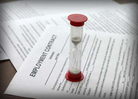 employment contract and hourglass, close-up