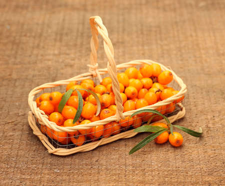 Useful sea-buckthorn berries in basket on wooden backgroundの写真素材