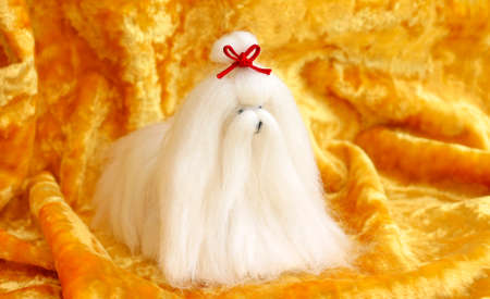 cute Maltese dog toy on yellow background, close-upの写真素材