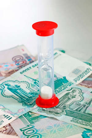 Idea of deadline and time is money - sandglass with russian rubles