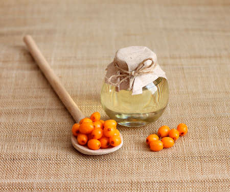 Sea buckthorn oil in glass jar, close-upの写真素材