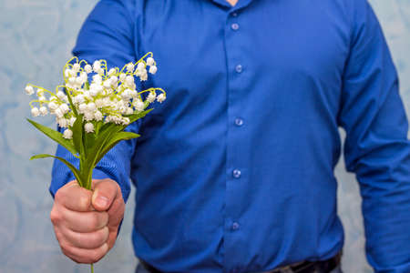 Elegant man holding lilies of valley. Gift on March 8の写真素材