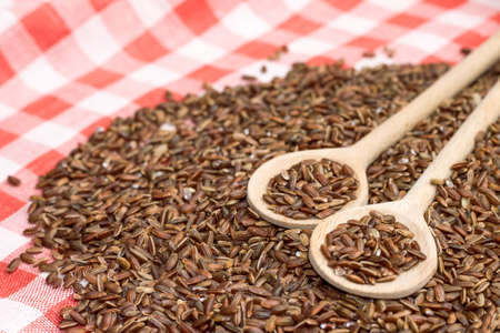 Studio photo of brown rice in wooden spoons, close-upの写真素材