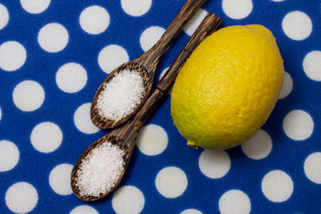 Citric acid in variegated wooden spoons, on blue polka dot backgroundの写真素材
