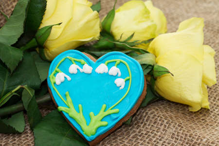 Glazed gingerbread and a bouquet of yellow rosesの写真素材