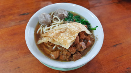 A Delicious Bowl of Mie Ayam on wood table. Indonesian Chicken Noodle Soupの写真素材
