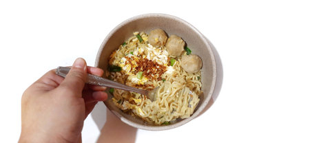 Instant noodle soup with egg and meatballs served on bowl isolated on white backgroundの写真素材