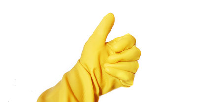 A human hand in yellow rubber glove showing a gesture thumb up isolated on a white backgroundの写真素材