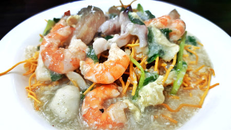 Mie kering or Mie titi, Indonesian food from Makassar served with seafood, meatballs, vegetables and sliced chicken meatの写真素材