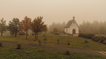 Suspenseful Foggy Autumn Scenery at a mountain monastery in Bavaria, Germany   Europe  Stratus in the mountains in an amazing misty landscapeの写真素材