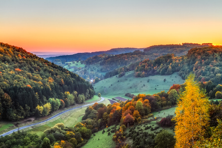 Idyllic Autumn Scenery with Colorful Orange Golden Trees near a lovely Country Road in the rocky Jura Mountains of Bavaria, Germany  Sunset in Fall with a wonderful clear sky in the rural countryside の写真素材
