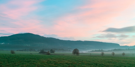 Foggy Morning Sunrise in Bavaria  Clear Sky  Hills and Forest  Barren trees and old grass  Beautiful rural landscapeの写真素材