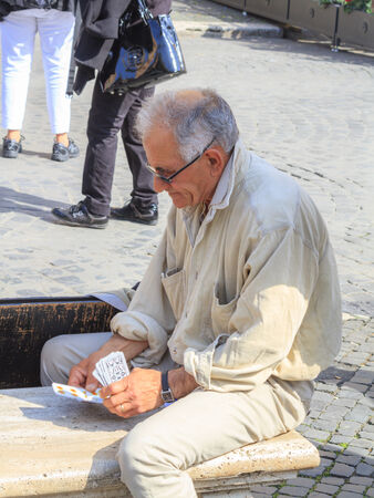 Editorial  ROME, ITALY - MARCH 29 2014  Male Old Man playing cards in the old town on MARCH 29 2014 in Rome in Italyのeditorial素材