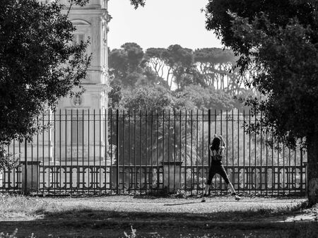 ROME, ITALY - MARCH 29 2014: Young adult woman doing stretching in the City Park of Rome on a warm spring morning on MARCH 29 2014 in Rome in Italyのeditorial素材