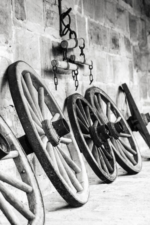 Vintage Picture of old wooden wheels on a castle in Bavaria, Germany in Europe . Still Life Picture. Stone walls.のeditorial素材