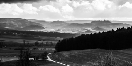 Dramatic Winter Landscape. German Winter Countryside with hills and barren trees. Castle on a hill. Lovely fairytale landscapeの写真素材