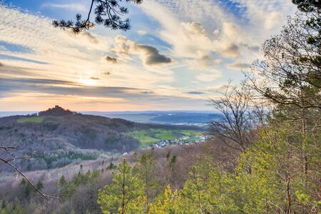 Sunset in the Hills of Franconia, Germany on an early April evening. Barren trees in the forrest. Panorama Format. Rural Countryside. Mountain Chapel and Castleのeditorial素材