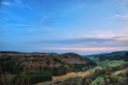 Springtime in Franconia, Germany. Landscape Image of a Hill Landscape near Rosdach with a beautiful country road in the evening, popular for motorcyclingの写真素材