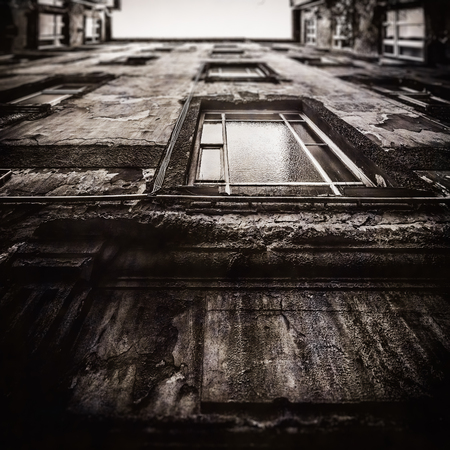 Berlin Apartment House. Reduced Sharpness and Area Tilt Shift Focus and Low Contrast Black and White Sepia for nostalgic Vintage Retro Look. Upwards View. Dilapidated Facade. City House in Germanyの写真素材
