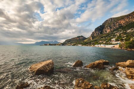 Sunrise at the Coast of Sicily. Dramatic Atmosphere with strong waves and clouds at Santa Flavia near Palermo, Italy in Europe in Autumn, Octoberの写真素材