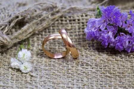 wedding rings and flowers on a linen background.の写真素材