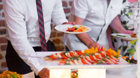 People group catering buffet food indoor in luxury restaurant with meat colorful fruits and vegetables.の写真素材