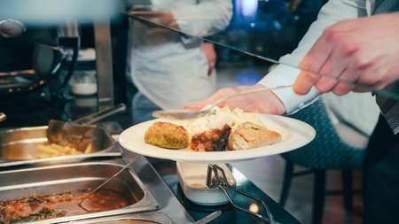 buffet: people take food in plates.の写真素材