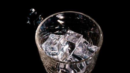 Ice cubes fall into a glass.の写真素材
