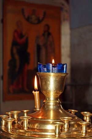 One candle in golden-blue candlestickの写真素材