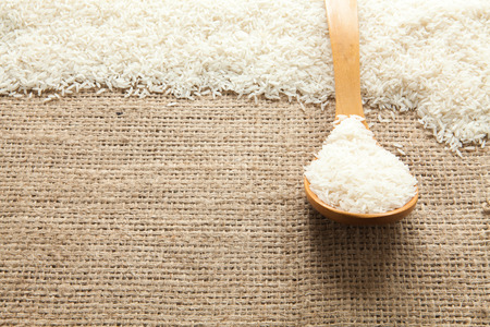 Grains of rice seen from above pouch of jute naturally illuminated with lightの写真素材