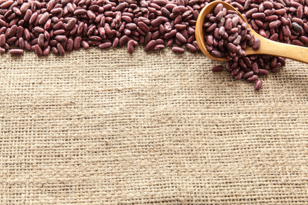 Red beans viewed from above on white wooden background naturally illuminated with lightの写真素材
