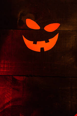 Halloween picture with the face of a pumpkin on wooden backgroundの写真素材