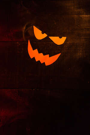 Halloween picture with the face of a pumpkin on wooden backgroundの写真素材
