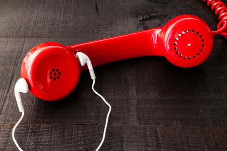 The retro red telephone. The image above dealer in vintage red phone on a dark wood background...