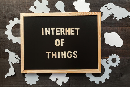 Chalkboard The Internet of Things concept. Wooden letters on slate and wood background with a concept message about the internet of things and gearwheelsの写真素材