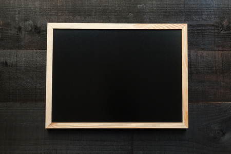 Chalkboard to write a concept. Wooden letters on slate and wood background with a concept message