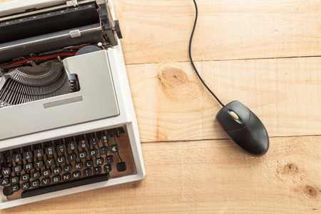 The picture shows an old typewriter connected to a computer mouse