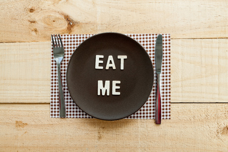 The image shows a wooden table with a plate and cutlery as seasonal rustic decor as backgroundの写真素材