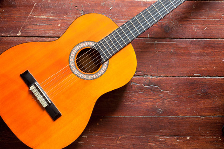 Flamenco guitar on wood background illuminated naturally by daylight