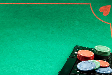 Image shows casino gambling chips on computer showing the concept of online card games