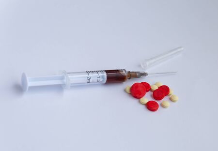 small syringe with color pills