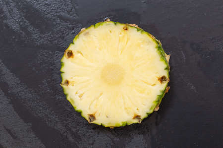 pineapple slice on a wet stone slab top view.の写真素材