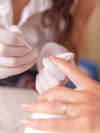 Manicure process in a beauty salon. Close-up of a woman's hands doing manicure.の写真素材