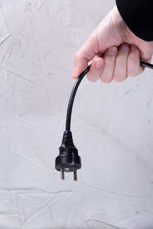 hand hold an electrical plug from an electrical appliance. blackout, electric shock, electricity...